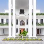 Luxury mansion exterior in Lagos, with neoclassical design, and lush balcony greenery