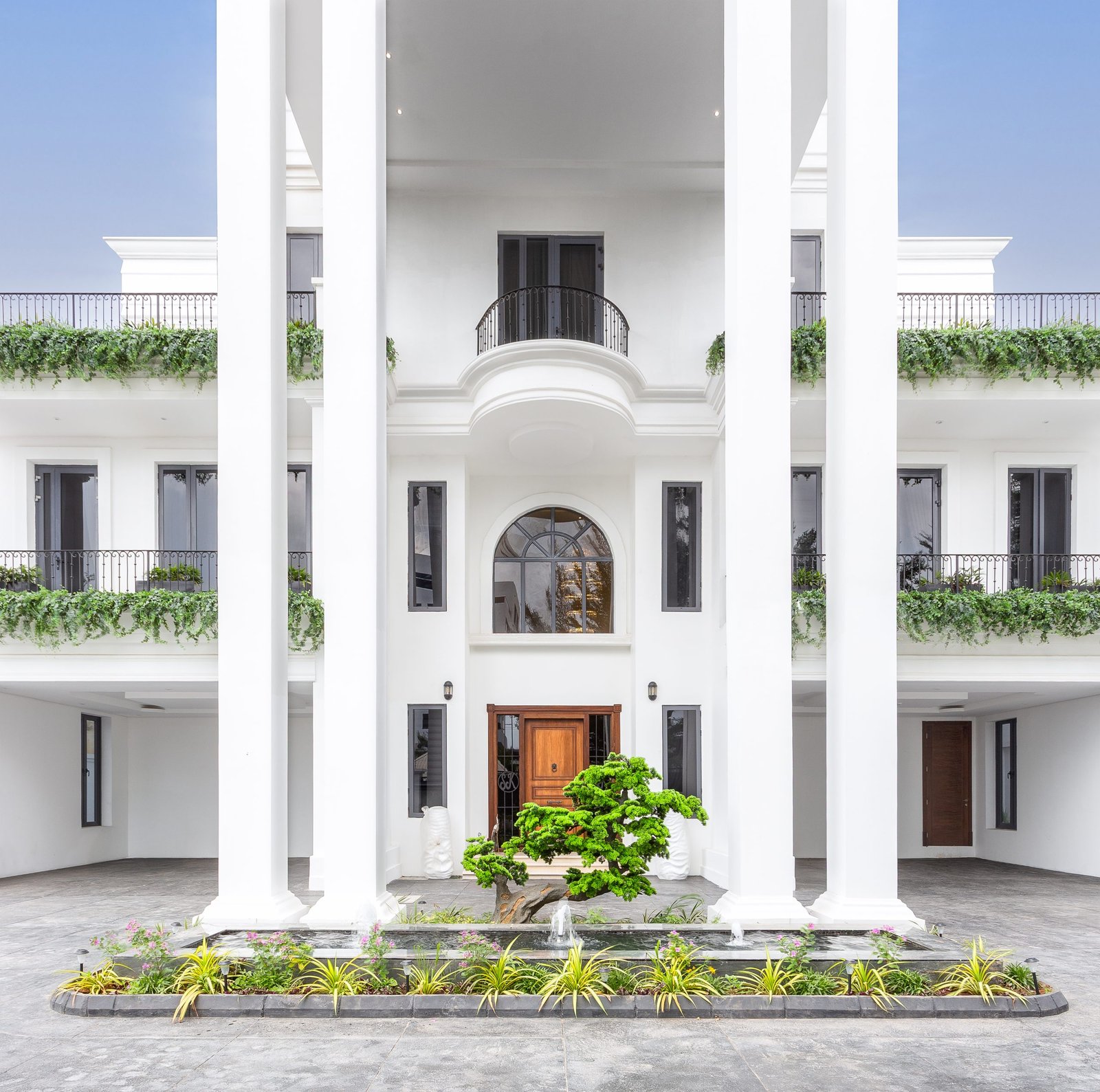 Luxury mansion exterior in Lagos, with neoclassical design, and lush balcony greenery